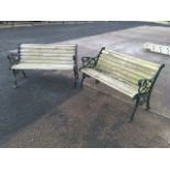 A pair of garden benches with shaped slatted backs & seats, the cast ends with pierced scrolled