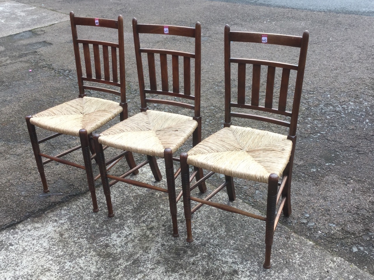 A set of three William Birch rush seated chairs, the rounded backs with slats, raised on ring-turned