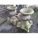 A pair of nineteenth century sandstone urns raised on associated scrolled bases, the campana