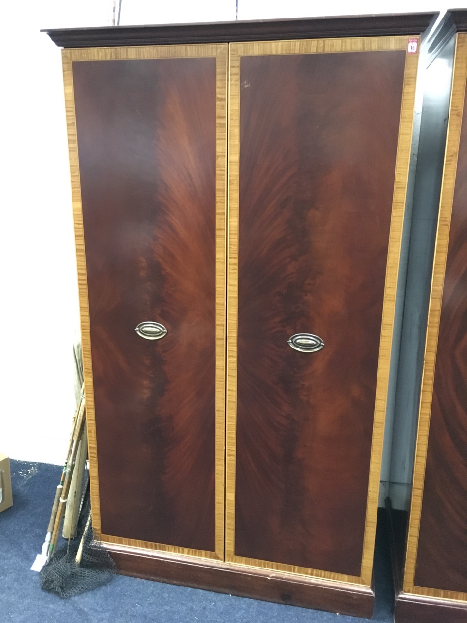 A large mahogany wardrobe with satinwood crossbanded doors enclosing shelves & hanging space, raised