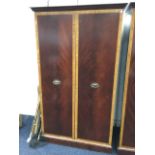 A large mahogany wardrobe with satinwood crossbanded doors enclosing shelves & hanging space, raised