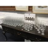 Two dozen boxed wine glasses; 4 champagne glasses; and 48 Carling pint glasses. (76)