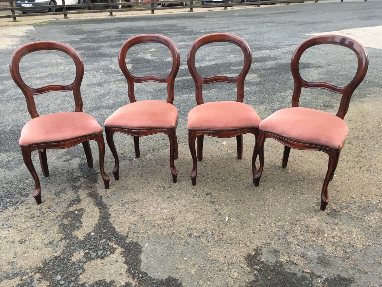 A set of four balloon back dining chairs with studded upholstered seats raised on cabriole legs. (