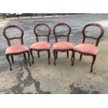 A set of four balloon back dining chairs with studded upholstered seats raised on cabriole legs. (