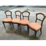 A set of four Victorian oak dining chairs with shield shaped arched backs and joining rails carved