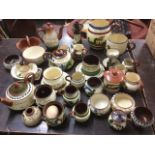 A large collection of terracotta Devon mottoware including jugs, bowls, jampots, candlesticks,