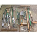 A quantity of garden tools including spades, rakes, choppers, brushes, shears, forks, hoes, etc. (