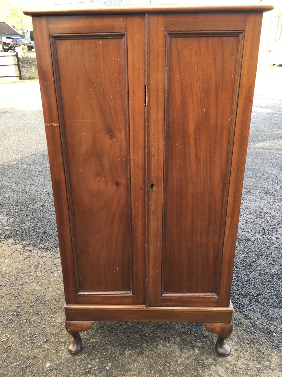 A mahogany cabinet with panelled doors enclosing shelves, raised on stub cabriole legs. - Image 2 of 3