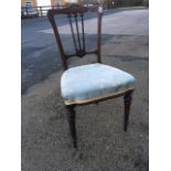 A Victorian chair with spindle back beneath scroll carved rail, the upholstered seat on fluted