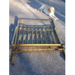 A late nineteenth century brass bed, the high headboard with vertical bars beneath rail, and