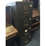 A metal filing cabinet with four drawers mounted with tubular handles.