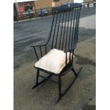 A 70s Swedish ebonised rocking chair, with arched spindle back and shaped arms above a wide seat