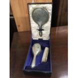 A cased silver plated ladies dressing table set with velvet lined interior.