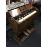 A portable collapsable Victorian harmonium, the walnut cased instrument with four octave keyboard