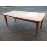 A late Victorian oak dining table, with telescopic action having two spare leaves with crank handle,