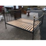 A super-king Victorian style iron & brass bed, the head & tailboards with concave brass rails, and