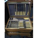 An oak cased Edwardian canteen of silver plated cutlery, the box with brass mounts containing two