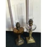 A Victorian brass oil lamp with scroll embossed weighted base beneath fluted amber glass