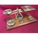 A set of brass postal scales, the warranted balance complete with full set of weights on mahogany