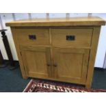 A contemporary oak sideboard, the cleated rectangular top above two frieze drawers and panelled door