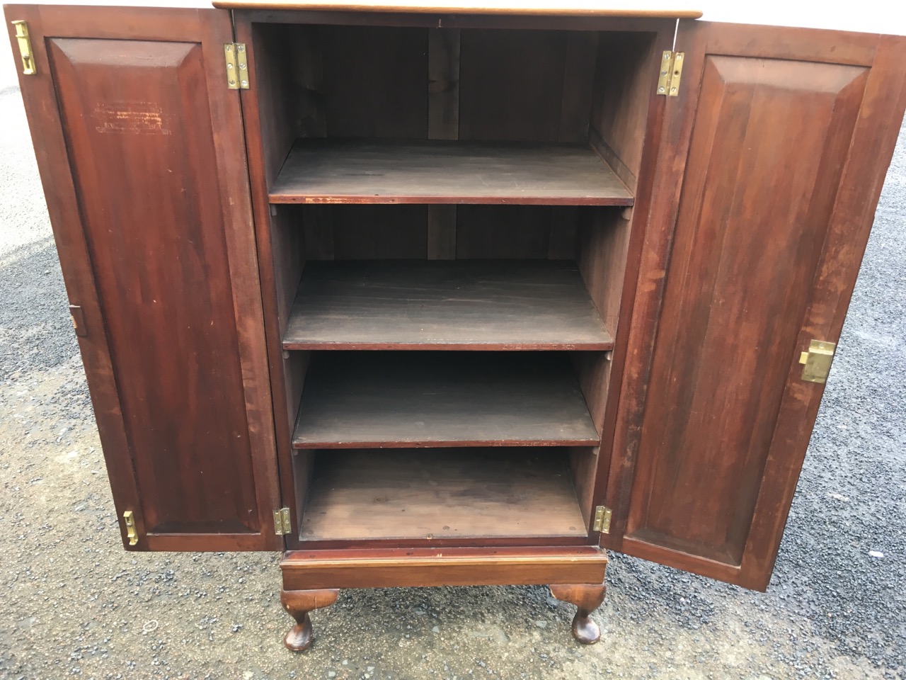 A mahogany cabinet with panelled doors enclosing shelves, raised on stub cabriole legs. - Image 3 of 3