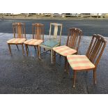 A set of four G-plan oak dining chairs with slatted backs above upholstered seats, raised on