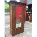 A Shapland & Petter oak wardrobe with projecting cornice on curved brackets above a bevelled glass