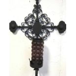 A wrought iron wall sconce, the cross metalwork with scrolled decoration supporting a candlelight in
