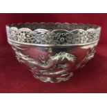 A Chinese silver bowl embossed in relief with dragons and sun in clouds motif beneath a floral