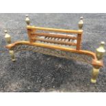 An Adams style firegrate with brass urn style finials above a pierced scrolled grill apron, with