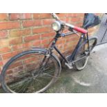 A three-speed Raleigh 1950s bicycle, with sprung seat, dynamo with lights, chain guard, barrel lock,