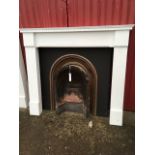 A chimneypiece with cast iron insert, having arched frame to aperture with firebrick back, the