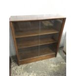 A mahogany bookcase with sliding glass doors above a plinth.