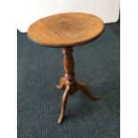 A circular oak occasional table, with bead moulding to top raised on baluster turned column with