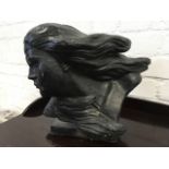 A painted composition stone head of a lady, modelled with flowing hair.