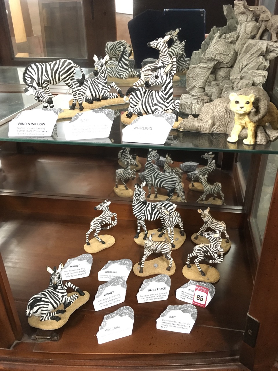 A collection of zebras with accompanying titles on faux rocks; a similar elephant and tiger model