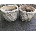 A pair of composition stone garden urns moulded with latticework beneath oak leaf and acorn borders.