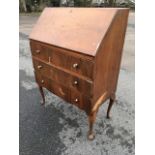 A 60s walnut bureau having fallfront enclosing pigeonholes and small drawer, with three long drawers