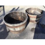 A pair of barrel garden tubs, each with oak staves bound by three metal strap bands. (2)