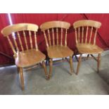 A set of three beech spindleback kitchen chairs, with solid seats raised on turned legs &