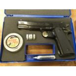 A cased .177 Colt government 1911 A1 model air pistol, the gun with four eight shot magazines, tin