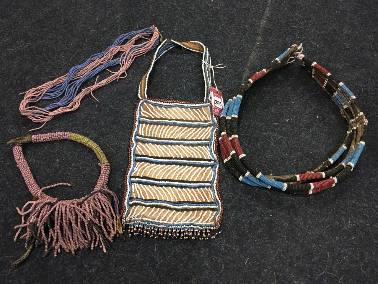 Miscellaneous tribal Zulu beadwork pieces - a necklace with tassels, a bag, a six cord belt (?), and