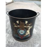 A large tubular log bin, the tub with handles and rolled rim decorated with armorial stye crest. (