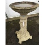 A composition stone birdbath, with circular fluted bowl on column cast with birds and foliage,