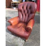 A modern leather button upholstered armchair, the spoonback above flared arms and loose cushion