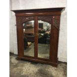 An art nouveau Maples mahogany wardrobe, with overhanging moulded dentil cornice and cushion