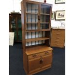 A 70s G-plan teak dresser, the glazed top with adjustable shelves above a base with long drawer