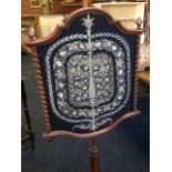 A Victorian walnut firescreen, the turned pole with leaf carved finial supporting shield shaped