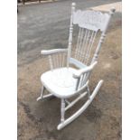 A painted American rocking chair, with foliate scrolled decoration to back rail on slender spindles,