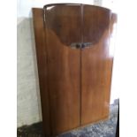 A 50s walnut wardrobe, with shaped veneered panels to doors, mounted with pierced rose brass